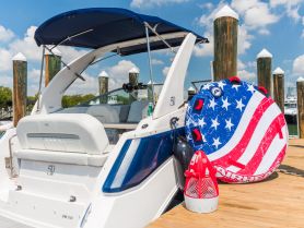A vibrant tubing device and cooler are displayed on the deck of a sleek boat, showcasing the perfect setup for a fun day on the water.