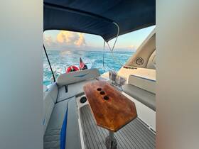 A cozy interior view of a boat featuring comfortable seating and a stylish wooden table, perfect for relaxing while cruising on the water.