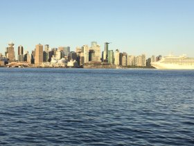 A stunning view of Vancouver's skyline from the water, featuring a prominent cruise ship and the city's iconic architecture — perfect for showcasing urban waterfront experiences.
