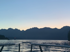 A serene sunset view from a boat, showcasing the silhouette of mountains against the colorful sky — perfect for peaceful evening cruises.