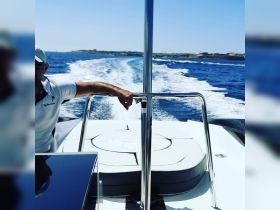 A captain navigates a sleek boat through sparkling blue waters, showcasing the thrill of a day on the water.