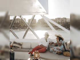 A couple enjoys drinks on a luxurious yacht, surrounded by stunning views — perfect for romantic getaways or sunset cruises.