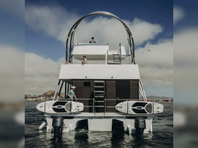 Guests enjoy their time aboard a stylish boat, with paddleboards ready for adventure — perfect for water sports enthusiasts.
