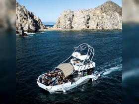 A lively group enjoys a scenic boat ride along the stunning coastline, showcasing the beauty of the surrounding cliffs and clear waters.
