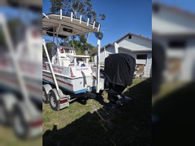 A well-maintained boat on its trailer, showcasing its structure and features, perfect for fishing adventures or leisure outings.