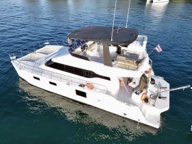 A stunning aerial view of a luxurious yacht docked in calm waters, showcasing its sleek design and spacious deck, perfect for relaxing on the water.