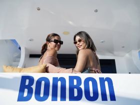 Two friends enjoy a sunny day aboard the BonBon, showcasing a relaxed atmosphere perfect for socializing on the water.