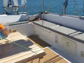 A cozy interior view of a boat's seating area, featuring a wooden table and comfortable cushions, perfect for relaxing while enjoying the sea.