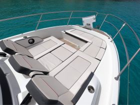 A spacious lounge area on a boat featuring comfortable seating, perfect for relaxing while enjoying the beautiful turquoise waters.
