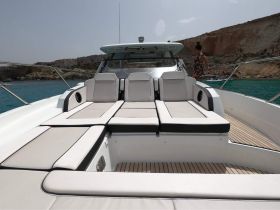 A stylish lounge area on a boat featuring comfortable seating, perfect for relaxing while enjoying the scenic views of the coastline.
