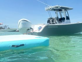 A sleek Sportsman boat is anchored in clear waters, showcasing its modern design and features — perfect for fishing or leisure outings.