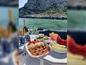 A beautifully arranged spread of charcuterie, fresh fruits, and drinks on a boat, perfect for a relaxing day on the water.
