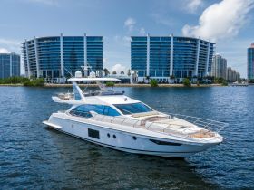 A stunning yacht cruising through calm waters, framed by modern high-rise buildings — perfect for luxury charters and waterfront views.