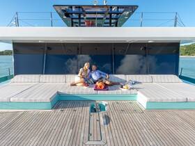 A couple enjoys a relaxing moment on the spacious deck of a luxury yacht, perfect for sunbathing and unwinding in a beautiful setting.