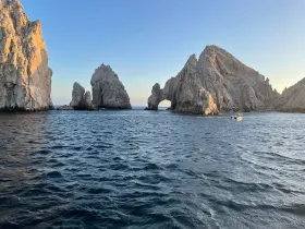 A stunning view of iconic rock formations at sunset, with a boat navigating the waters — a perfect representation of coastal beauty and adventure.