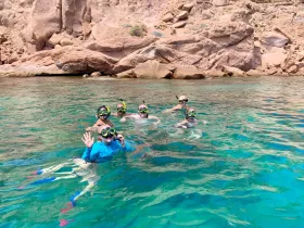 A joyful group of snorkelers enjoys the vibrant underwater world in crystal-clear waters, making for an unforgettable aquatic adventure.