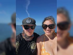 A cheerful couple enjoys a sunny day on the water, showcasing the perfect outdoor experience for boating enthusiasts.