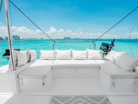 A stylish lounge area on a boat, featuring plush seating and a stunning view of the turquoise waters, perfect for relaxation during a day on the water.