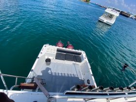A clear view of the back of a speedboat anchored in calm waters, showcasing its sleek design and features, perfect for a day out on the water.