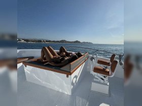 A group of friends relaxes on the deck of a boat, soaking up the sun and enjoying the ocean views — a perfect day for leisure on the water.