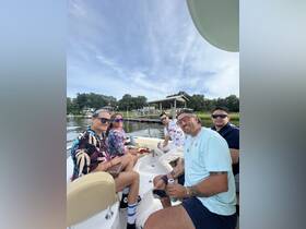 A lively group of friends enjoys drinks and snacks aboard a boat, capturing the essence of a fun day on the water.