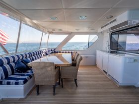 A spacious and elegantly designed interior of a yacht featuring comfortable seating and a dining area, perfect for enjoying meals while cruising on the water.