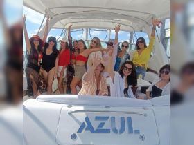 A lively group of friends celebrates aboard the AZUI yacht, showcasing the joy of a fun day on the water.
