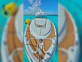 A stunning view of the front of a yacht, showcasing its sleek design and luxurious features against a backdrop of vibrant turquoise waters.