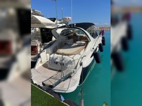 A stunning view of the yacht 'Cornelia' docked in clear turquoise waters, showcasing its elegant design and spacious deck, perfect for luxury outings.