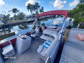 A well-appointed interior view of a pontoon boat, showcasing comfortable seating and a helm, perfect for relaxing on the water.