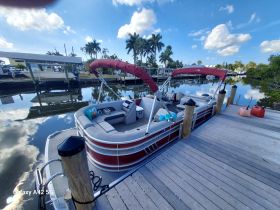 A beautiful pontoon boat docked at a marina, showcasing its spacious seating and inviting design, perfect for leisurely outings on the water.