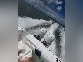 A dynamic view of a speedboat in motion, showcasing the powerful twin engines and the wake created as it glides across the water.