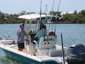 Two friends enjoy a day of fishing on a boat, showcasing camaraderie and the thrill of outdoor adventures on the water.