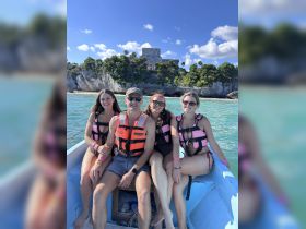 A group of friends enjoys a boat ride near Tulum, showcasing the stunning backdrop of ancient ruins — perfect for adventure seekers and cultural explorations.