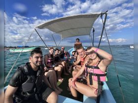 A lively group enjoys a snorkeling adventure aboard a small boat, capturing the excitement of their ocean experience.