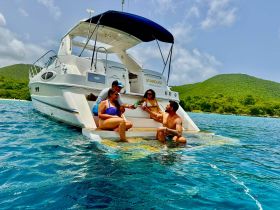 A lively group enjoys a refreshing day on the water, relaxing and swimming off the back of their boat, 'Stardust,' in the beautiful Virgin Islands.