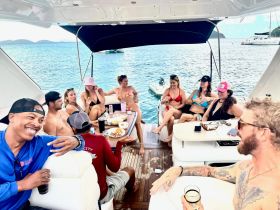 A lively group enjoys drinks and conversation aboard a boat, creating a perfect atmosphere for celebration and relaxation on the water.
