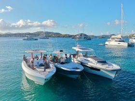 A lively group enjoys a day on the water aboard two boats, surrounded by stunning scenery — perfect for a fun-filled boating adventure.