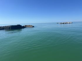 A serene view of calm waters with distant structures, but the image lacks clarity and detail.
