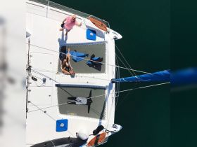 Aerial view of two people enjoying their time on a catamaran, showcasing a fun and relaxed atmosphere on the water.