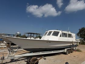 A well-maintained boat is docked and ready for use, showcasing its sleek design and structure against a clear blue sky.