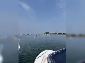 A serene view of a boat navigating through calm waters, surrounded by other vessels and a picturesque shoreline — ideal for showcasing boating adventures.