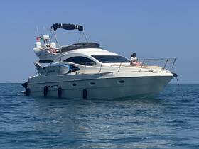 A woman relaxes on the bow of a luxurious yacht cruising through clear waters, perfect for enjoying a day on the ocean.