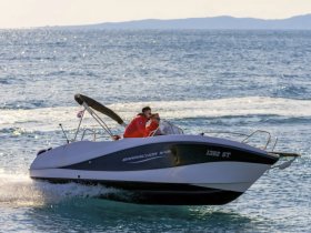 A speedboat glides across the shimmering waters, showcasing an exciting day on the sea with passengers enjoying the ride.