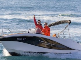 Two friends celebrate on a Barracuda 545 boat, enjoying a thrilling day on the ocean — perfect for adventure seekers and fun-loving groups.