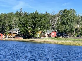A scenic view of a lakeside area with various buildings and greenery, but the focus is unclear.