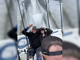 A cheerful group enjoys a fishing trip on a boat, capturing a fun moment together while cruising on the water.