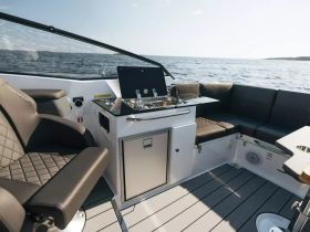 A sleek interior view of a modern boat showcasing the helm and comfortable seating area, perfect for relaxing while enjoying a day on the water.