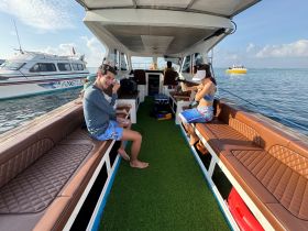 Inside view of a boat's cabin featuring comfortable seating, where guests relax and enjoy the scenic surroundings. Ideal for socializing and unwinding during a day on the water.