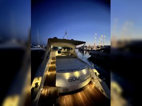 A beautifully lit yacht named '600 Sport' docked at night, showcasing its elegant design and inviting ambiance — perfect for evening cruises.